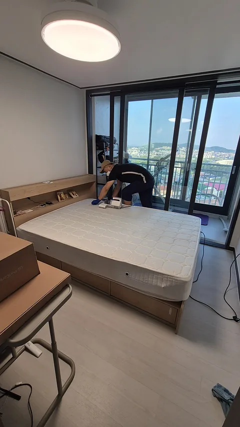 침구 전용 청소기로 매트리스 상판을 작업하는 모습