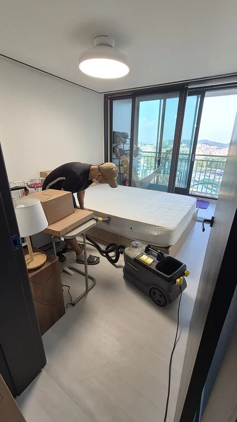 추출 장비와 호스를 두고 매트리스를 작업하는 모습